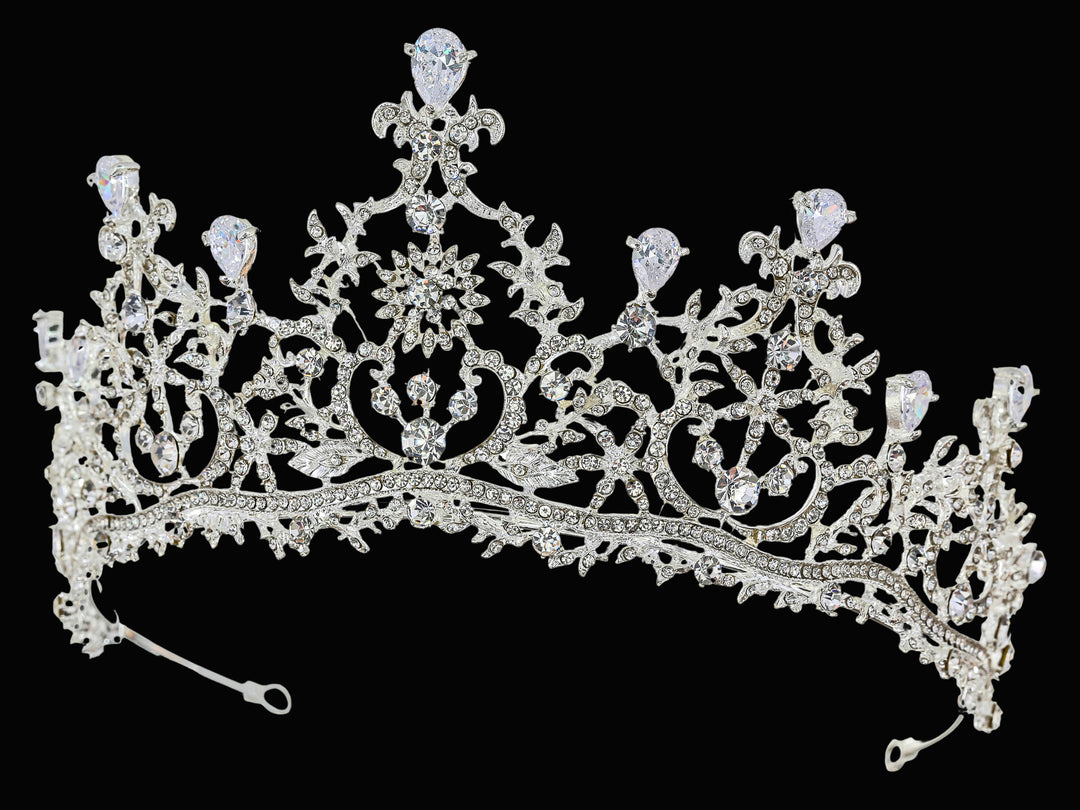 Front-facing studio shot of a silver-plated tiara featuring pear-cut rhinestones, floral scrollwork, and pavé-set crystals.